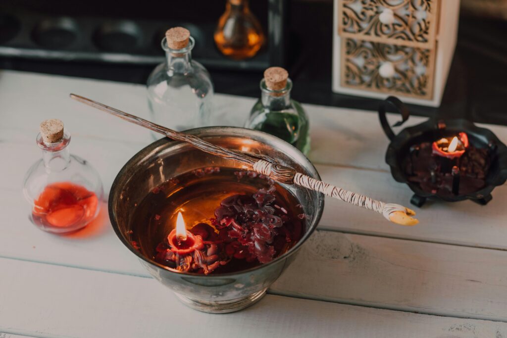 An enchanting scene of candles melting next to potion jars and a wooden wand.